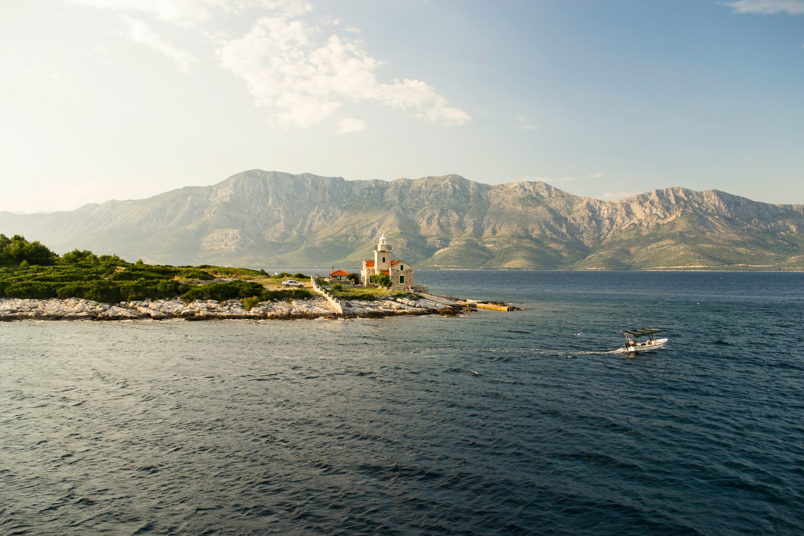 Lighthouse on rocky coast, serene waters. hvar