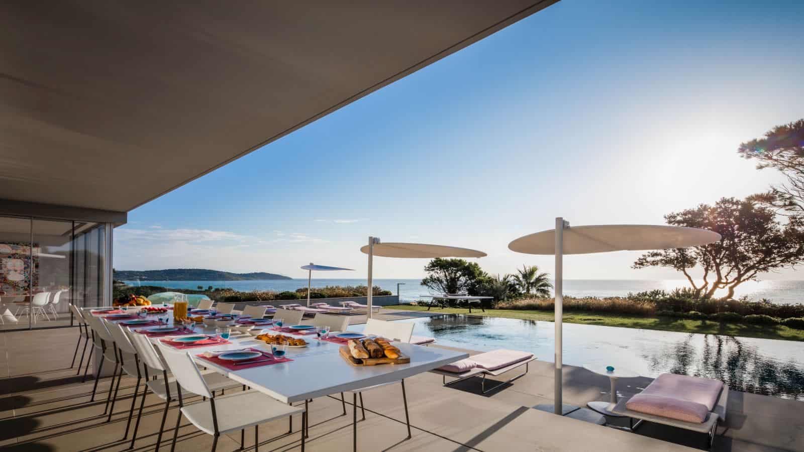 A Staffed Riviera Villa: Yacht Transfers, Beach-Club Tables and Private Chefs 2 Terrace dining table set for a group beside an infinity pool with sea views at a staffed French Riviera villa