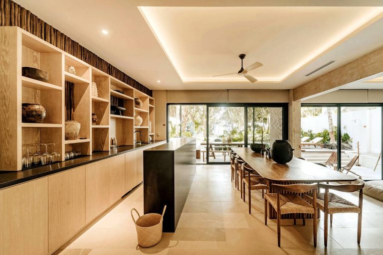 A kitchen and long dining table opening to the garden at a villa in Tulum