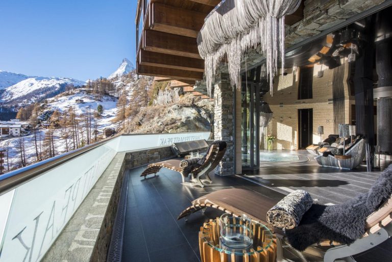 A balcony of Chalet Zermatt Peak in winter, above the snow-covered roofs of Zermatt