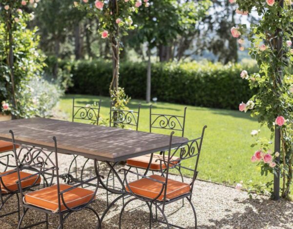 A garden table under climbing roses at Villa Rinascimento, near Florence