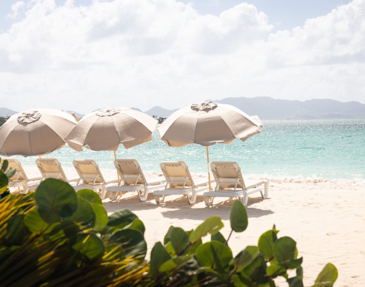 Anguilla Villas and Luxury Vacation Rentals 1 Beach loungers under umbrellas by water in Anguilla