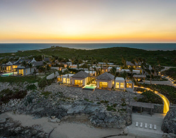 Luxury Villa Rentals and Mansions for Rent | Haute Retreats | 3 The villas and bungalows of Dream Estate lit at sunset above the sea on Ambergris Cay, Turks and Caicos