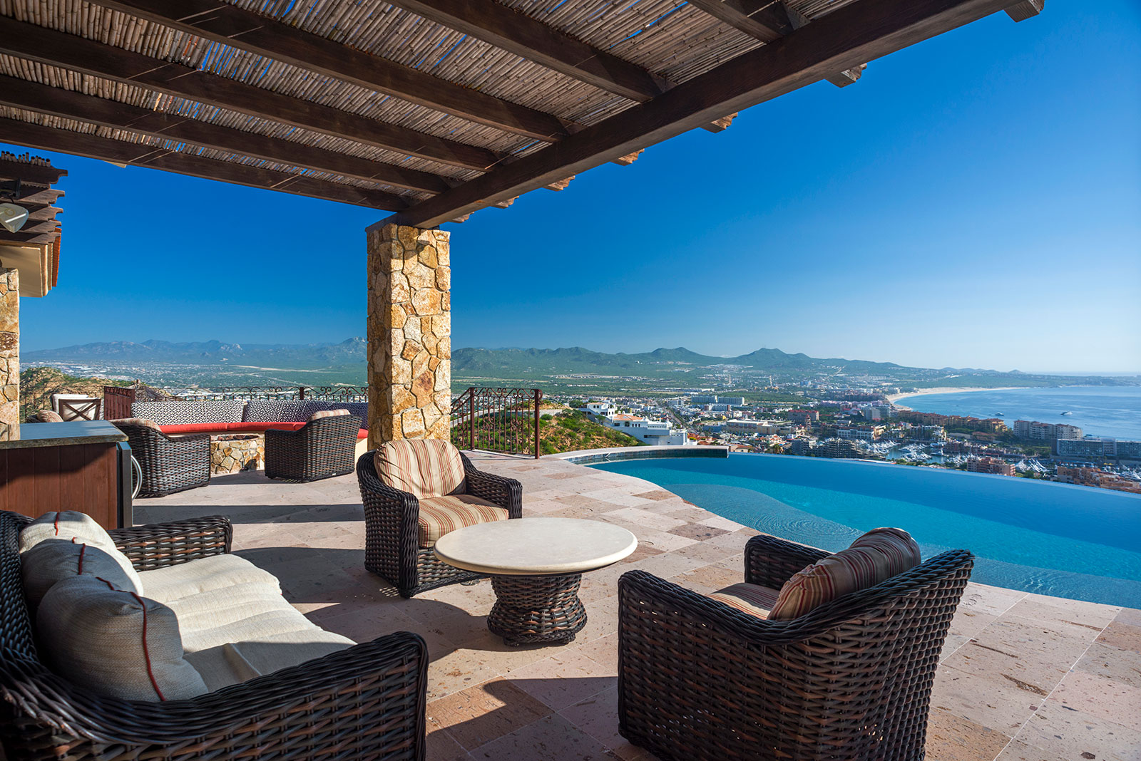a patio with a pool and chairs Villa cielo Pedregal Los Cabos