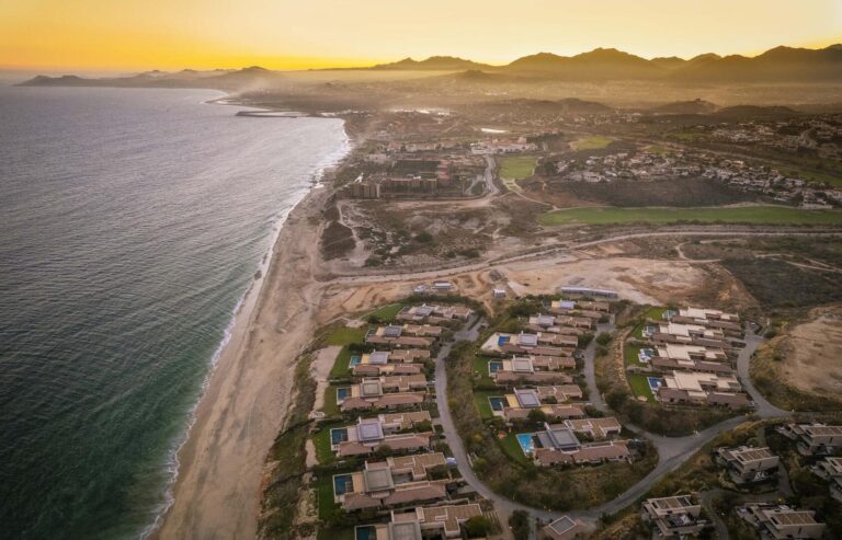 The beach and villas of Puerto Los Cabos from the air at sunset