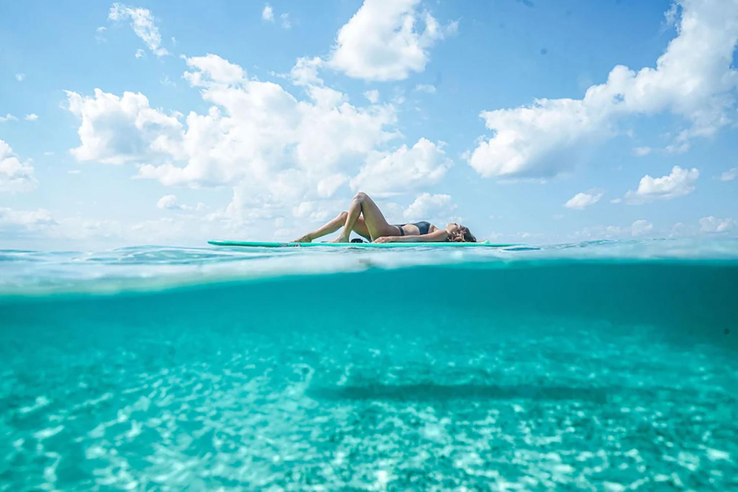 Woman relaxing on paddleboard in ocean