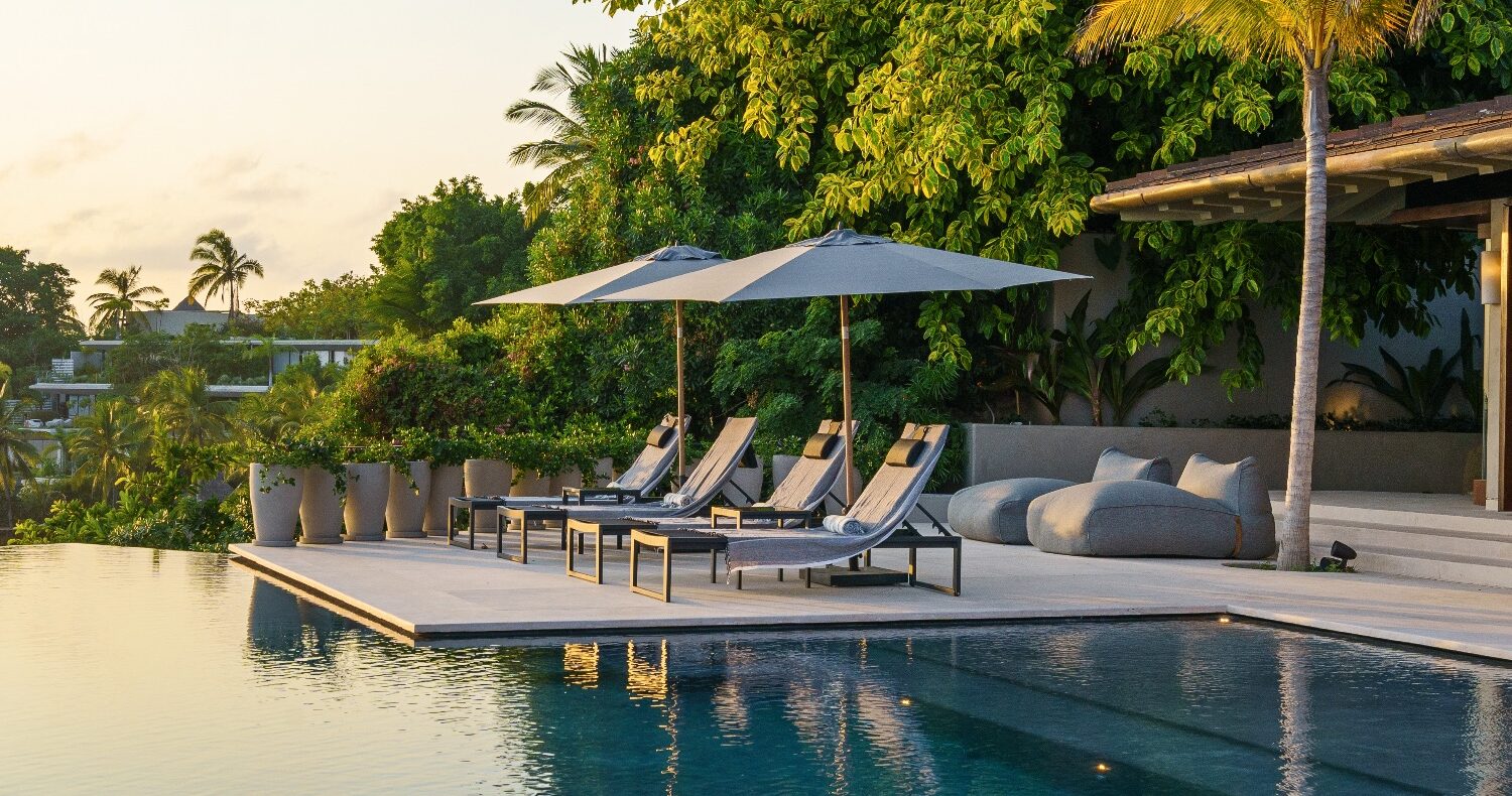 Luxury villa with serene poolside loungers.