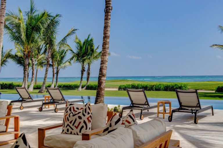 Outdoor sofas and loungers by the sea among palms