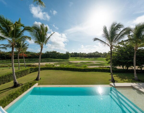 An infinity pool above a golf course lined with palms, Punta Cana