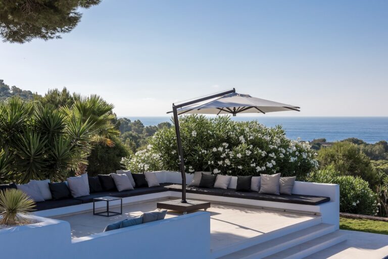 A shaded lounge terrace above the sea at a villa in Es Cubells, Ibiza