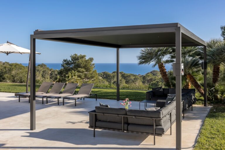 A pergola and lounge on a terrace above the sea at a villa in Ibiza