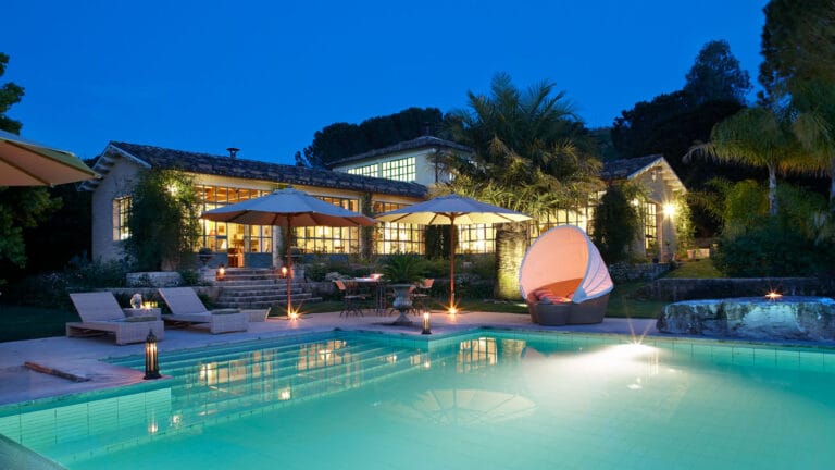 A villa in Sicily with its pool lit at dusk