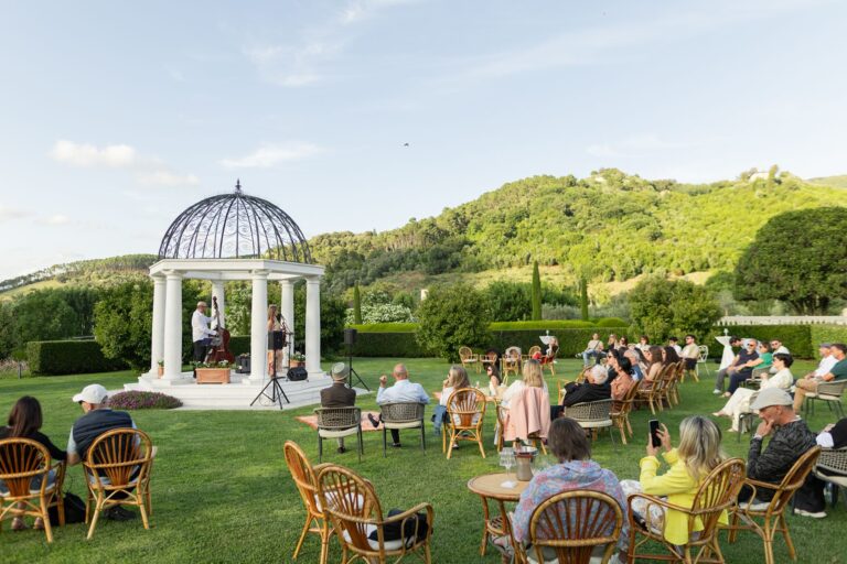 Tables set on the lawn around a white gazebo at Villa Maria, near Lucca